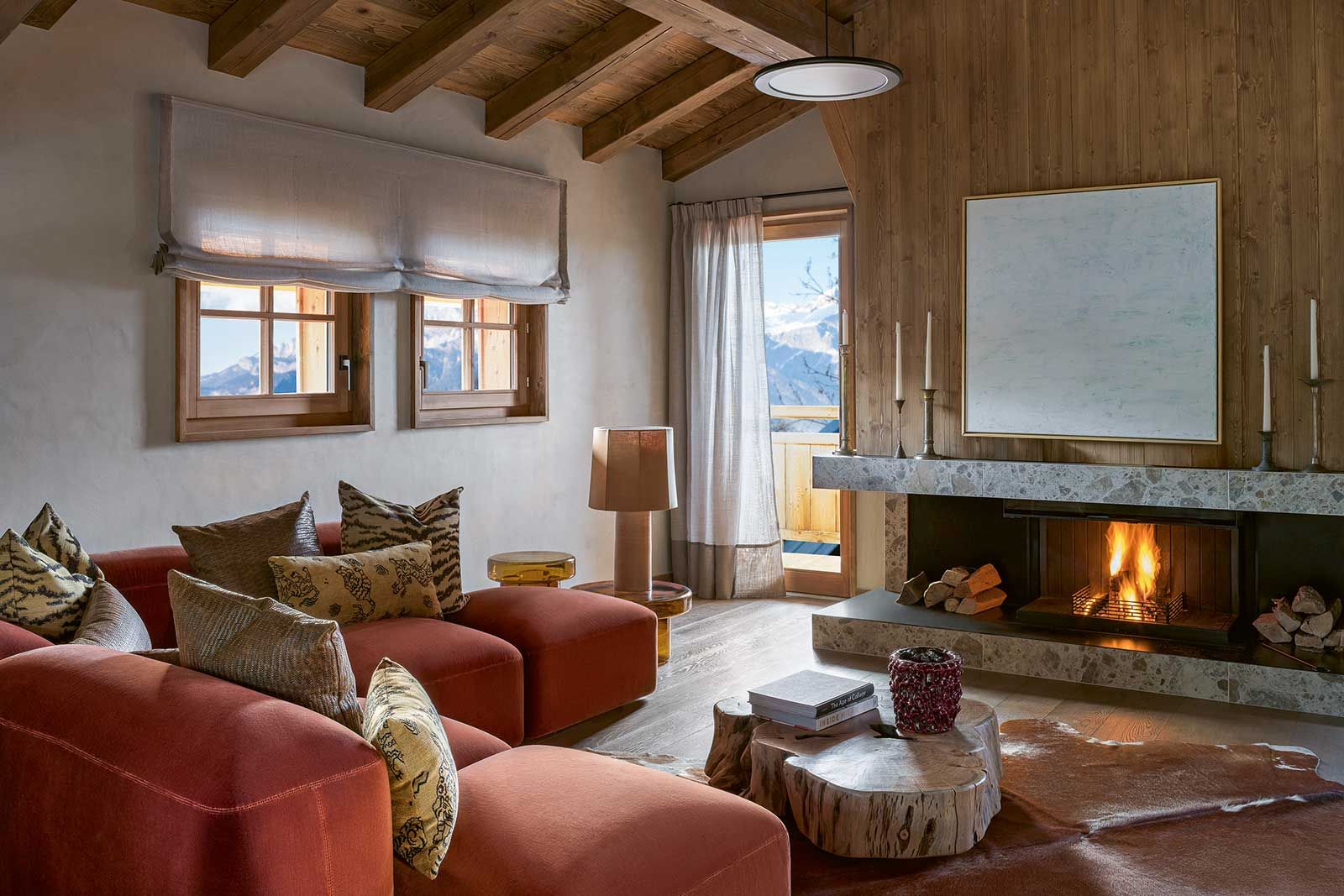 Das Sofa «Lapis» von Anton Cristell und Emanuel Gargano für Amura steht souverän im Raum, begleitet von Kissen aus Dedar-Stoffen, deren mutige Muster Bewegung und Tiefe verleihen. Die Tischleuchte von Nassi und die Beistelltische von Miniform formieren sich als dekoratives Trio vor der Terrassentür.