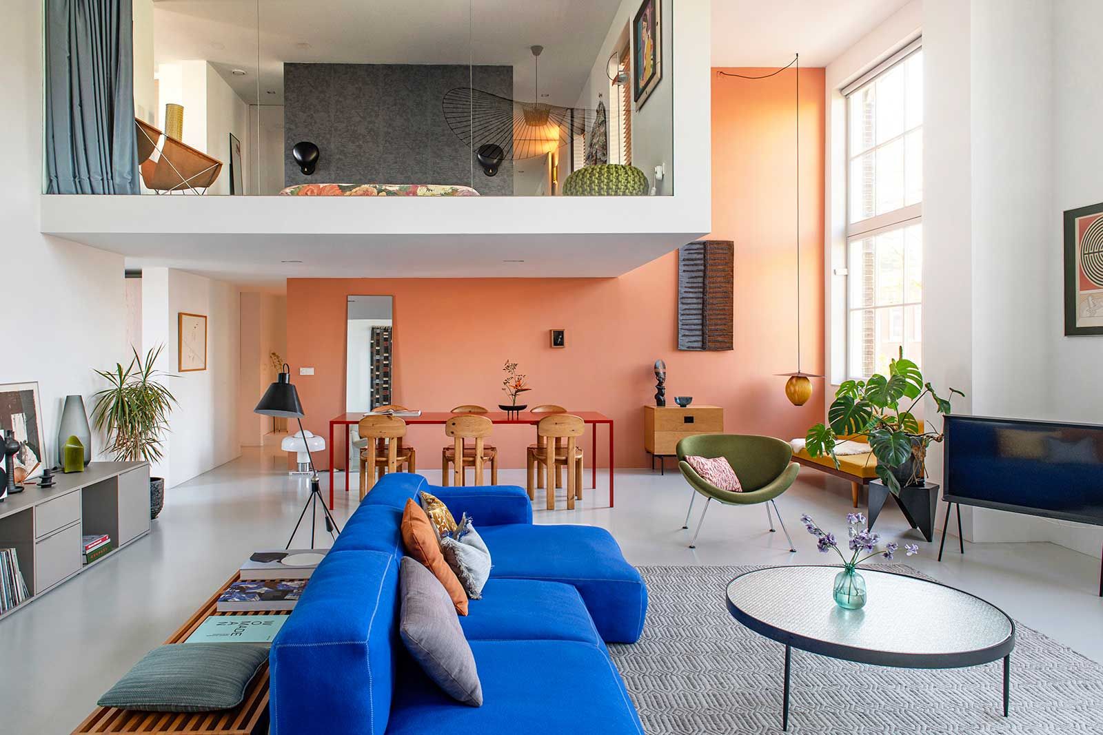 Der markante Kubus über dem Essplatz strukturiert den offenen Raum. Darunter steht ein «Arco Slim»-Tisch, nach einem Wasserfleck in japanischem Lackrot neu gefasst. Die Ess­zimmerstühle aus Kiefernholz werden Rainer Daumiller zugeschrieben. Ein «Orange Slice»-­Sessel von Pierre Paulin, einst im Besitz von Michelles Grossmutter, setzt einen ­weichen Akzent.