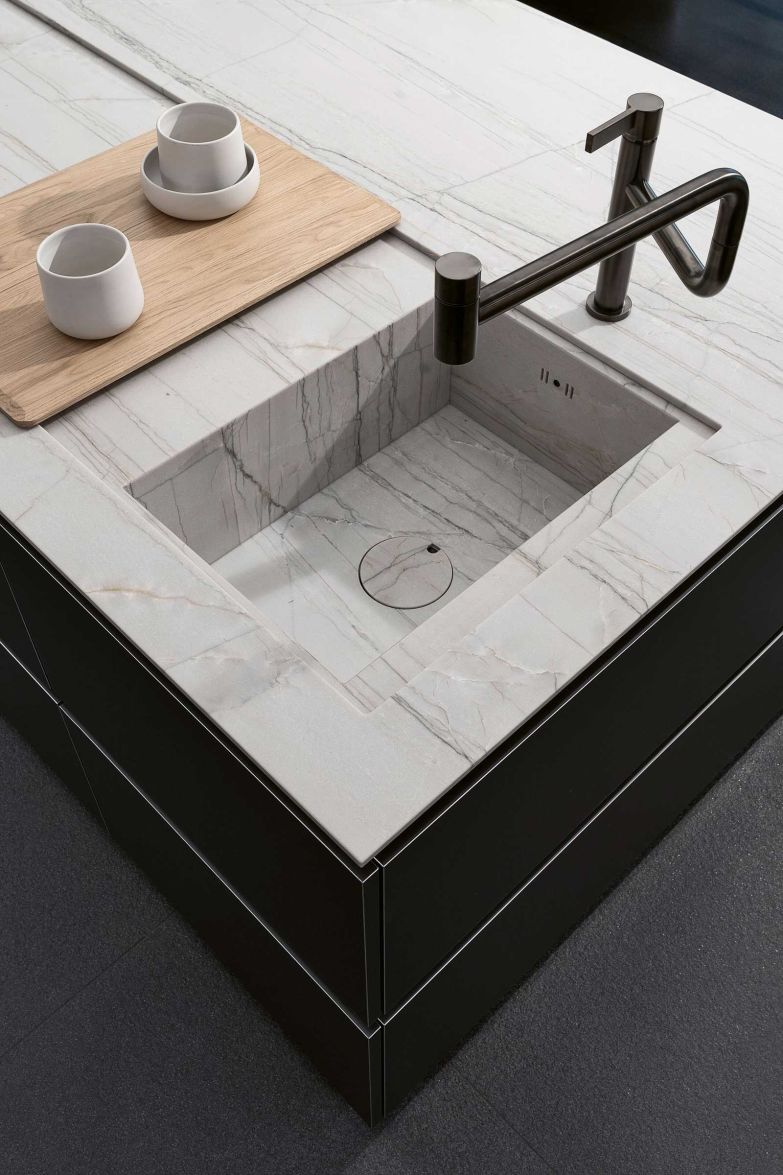 Mit Details wie der abgesenkten Funktionsfläche und dem Schneidebrett aus massiver Eiche setzt der deutsche Hersteller edle Akzente und macht den ­Küchenalltag angenehmer. poggenpohl.com