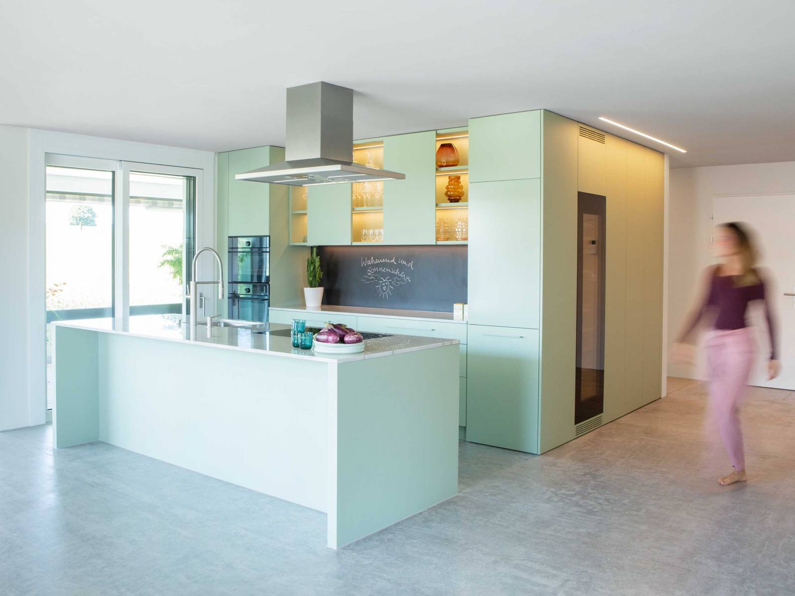 Bei dieser auf Mass gefertigten Küche des Appenzeller Unternehmens sind nicht nur die Oberschränke mit einem spannenden Mix aus geschlossenen und offenen Flächen, die beschreibbare Rückwand, sowie die stimmungsvolle dimmbare Beleuchtung nennenswert. Vor allem ist es der trendige Farbton Pistaziengrün, der jeden Tag für gute Laune sorgt. ELBAU. Foto: © Klaus Andorfer.