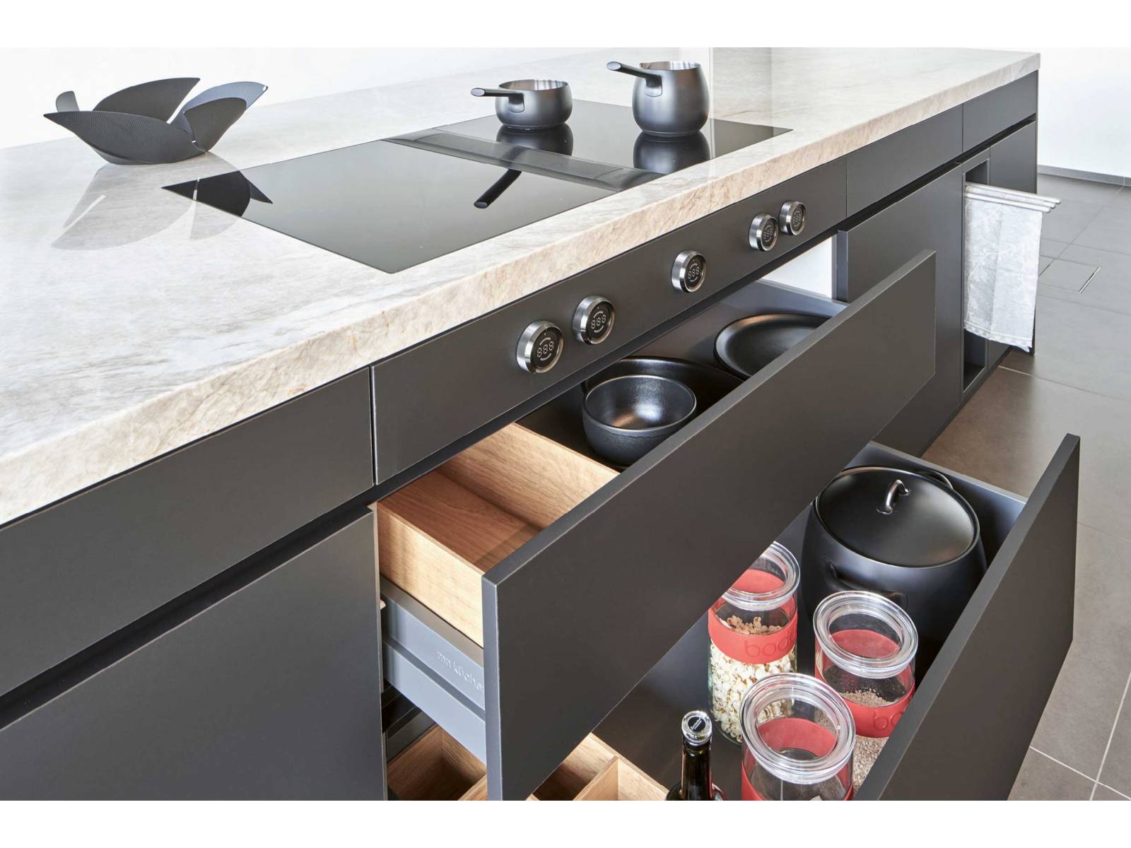 Die Küche «Ligna Elegance» des Liechtensteiner Küchenbauers wirkt modern und grosszügig mit ihren grifflosen Fronten in horizontal angeordnetem Eichenholzfurnier. Die integrierte Natursteinabdeckung bietet Platz zum Arbeiten und Geniessen und verwandelt die Küche in einen multifunktionalen Ort. MOVANORM.