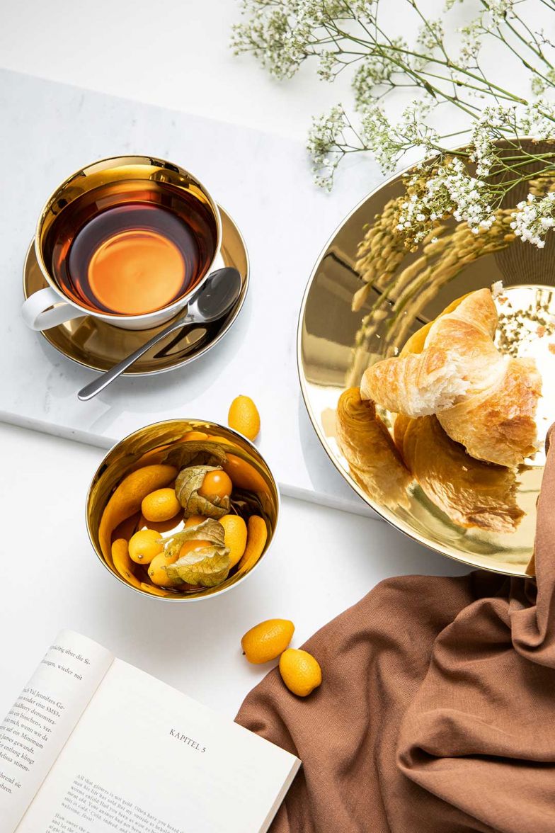 Zeit für eine heisse Tasse Tee ist immer – und stilvoll serviert im neuen Service «Tric Sunshine» aus weissem Porzellan mit goldener Innenglasur ist für glänzende Momente gesorgt. Arzberg.