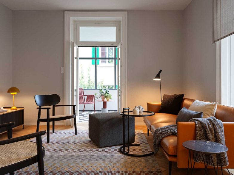 Das cognacfarbene Ledersofa von Muuto gibt im ­Wohnzimmer den Ton an. Der Wollteppich nimmt die Farben des Raums auf und hält ihn zusammen.