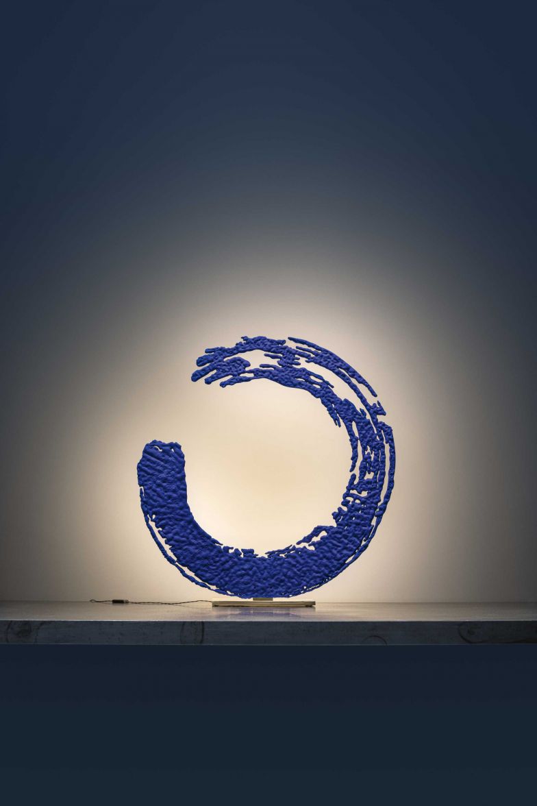 Inspiriert von der alten Kunst der japanischen Kalligraphie, hat Enzo Catellani die Leuchte «Enso» geschaffen, die als Allegorie für Vollständigkeit und Erleuchtung steht. Wie ein handgemalter blauer Kreis steht die Leuchte auf einem Messingsockel, beleuchtet von einer LED-Lichtquelle, die hinter der Leuchtenstruktur verborgen ist. CATELLANISMITH.COM