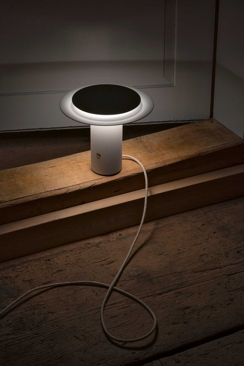 Die neuen Steh- und Tischleuchten der Kollektion «Glarona» von Jörg Boner inszenieren mit horizontalen Linien und Lichtflächen Licht und Schatten auf stille Weise. Das Licht reflektiert diffus auf dem pulverbeschichteten Metallblech und erzeugt so feine Lichtverläufe, die die papiergefaltete Formensprache der Leuchte betonen. Foto Jasmine Deporta. schaetti-leuchten.ch