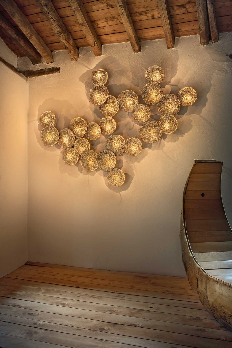 In der Wandleuchte «Gold Moon» wird die Faszination des Mondes lebendig: Goldene, metallisch schimmernde Scheiben reflektieren das Licht versteckter LED's und erzeugen dadurch faszinierende Schatten und zarte Reflexe. catellanismith.com