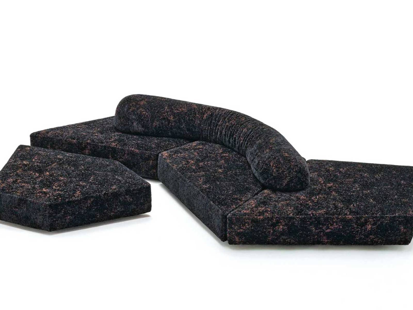 Wie geschliffener Obsidian liegt das Sofa «On the Rocks» im Raum. Der neue Stoff «Gems» bringt Glanz, Tiefe und eine fast mineralische Präsenz in die schwarze Fläche. EDRA.