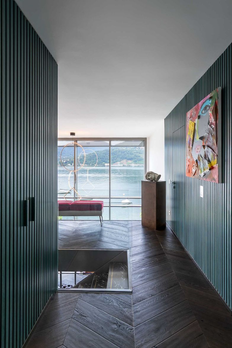 Das grosszügige Fenster reicht vom Wohnzimmer bis ins erste Geschoss. Die gepolsterte Bank verleiht dem Ausblick Museumscharakter.