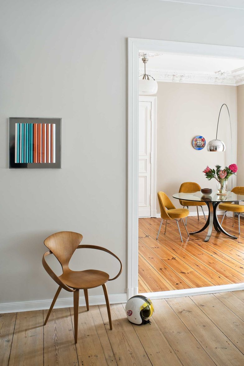 Blick aus dem Schlafzimmer durch die Zimmerflucht, die von Holstein in Absprache mit der Vermieterin neu herstellen liess: Im Vordergrund ein «Cherner Chair», dahinter im Esszimmer Saarinen «Executive Chairs» in Senfgelb um einen Glastisch, dazu die «Arco»-Stehleuchte von Achille Castiglioni für Flos.