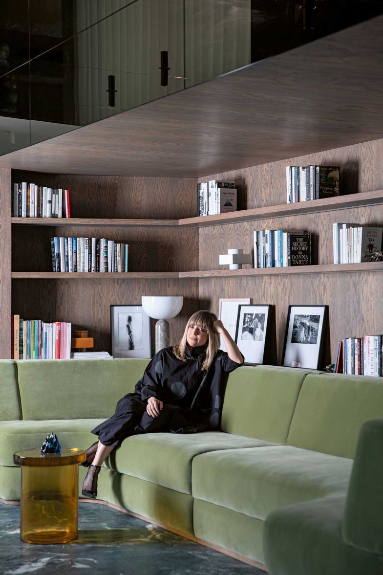 Das Sofa, auf dem die Innenarchitektin Róisín Lafferty sitzt, ist eine Massarbeit, die elegant in die tragende Wand integriert wurde. Darüber füllen Regale aus Holz die Nische und beherbergen eine sorgfältige Auswahl an Büchern, die den Raum um eine intellektuelle Note bereichern.